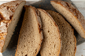 sliced rye bread on dark cutting board close up