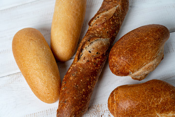 different mini baguettes on white wooden table