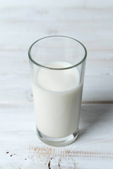 glass of milk on white wooden table