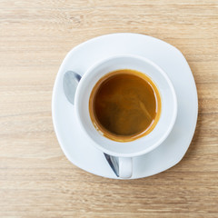Black coffee in white cup on wooden background.