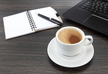 Obraz na płótnie Canvas cup of coffee and pen on a laptop