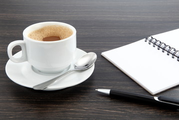 cup of coffee and notebook on table