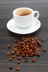 cup of coffee and beans on wooden background