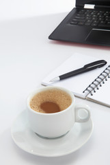 cup of coffee and pen on laptop