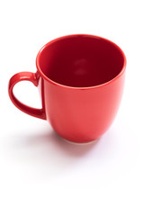 red ceramic mug on white background