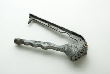 Garlic crush on isolate. Manual old device for chopping garlic on an isolated surface.