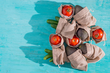 uncooked vegetables in hessian sack on turquoise  background