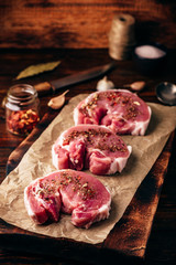 Raw pork loin steaks with different spices