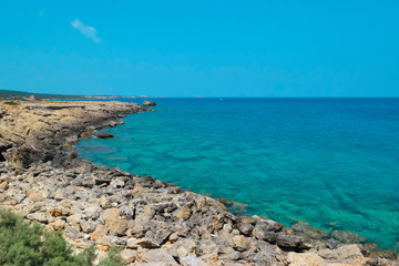 Fototapeta na wymiar rocky coastline on turquoise sea background 