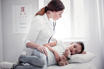 Fototapeta premium Sad ill girl lying on the medical bed