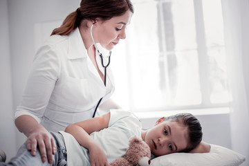 Nice female doctor using her professional stethoscope