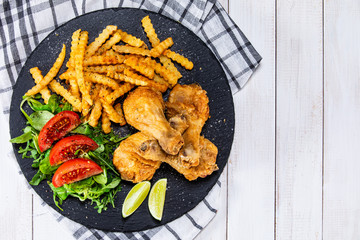 Grilled chicken drumsticks with french fries and vegetables