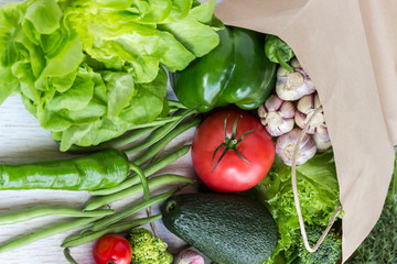 Healthy food in paper bag of different  vegetables on white background. Top view.