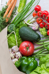 Healthy food in paper bag of different  vegetables on white background. Top view.