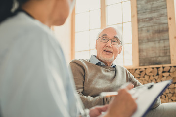 Wise old man having comfortable conversation with nurse