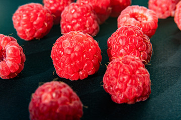 Fresh organic raspberries background closeup. Fresh raspberries on black background