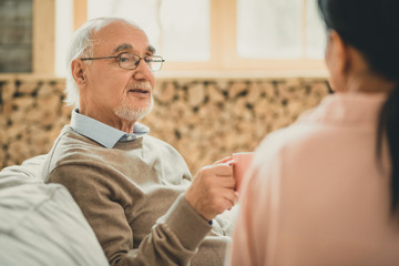 Old grey-haired man having pleasant time with his female friend