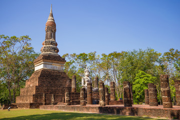 Fototapeta na wymiar Sculpture of a sitting Buddha on the ruins of an ancient Buddhist temple, Sukhothai. Thailand