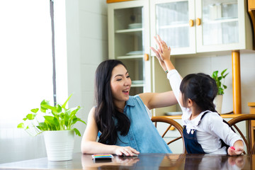 happy mom and daughter having fun at home
