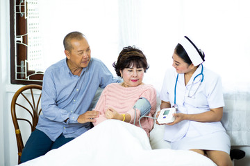 Nurse measuring blood pressure of senior woman at home. health insurance concept