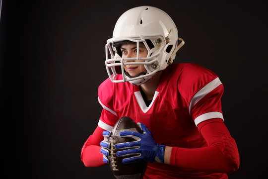 Image of american woman football player in helmet with rugby ball in hands