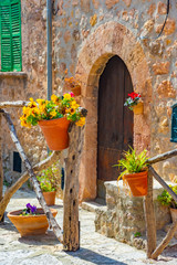 Fototapeta na wymiar Beautiful window with flower pots and colorful flowers serving as a decoration of the facade. Spanish village Valldemossa, Mallorca, Spain