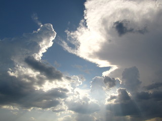  The rays of the sun shine from behind the clouds. Sky background, natural colors. Sky before a thunderstorm.