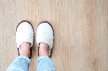 Woman's legs in white woolen slippers