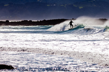 Silhouette surfer surfing big wave ocean surf