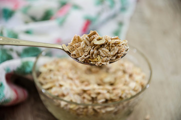 oatmeal on a spoon against the background of a glass of milk and a plate of porridge.
