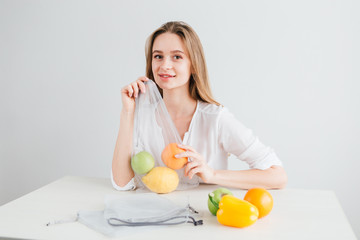 Girl packs the vegetables and fruits in a reusable cloth bag