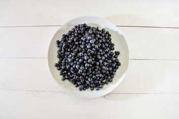 tasty blueberries in a plate on white. Close-up. View from above.