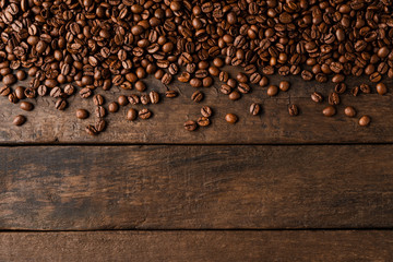 Coffee beans on wooden background with copyspace.