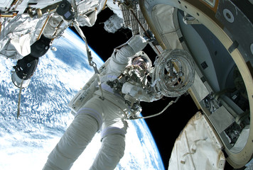 The astronaut in a space suit, in an outer space, is engaged in repair of the space station.  Elements of this image were furnished by NASA