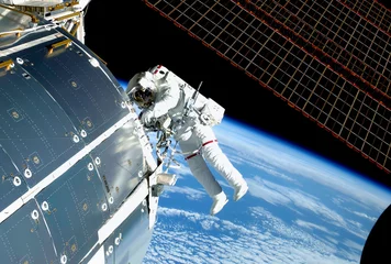 Fotobehang De astronaut in de ruimte, bij het ISS, repareert en experimenteert. Elementen van deze afbeelding zijn geleverd door NASA © Artsiom P