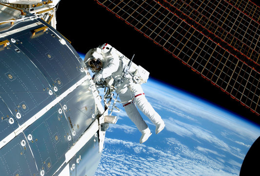 The astronaut in an outer space, at the ISS, repairs and makes experiments. Elements of this image were furnished by NASA - Powered by Adobe