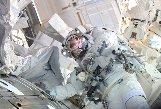 The astronaut in a space suit, in the ISS, lasts a hand in the camera.  Elements of this image were furnished by NASA