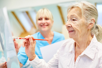 Senior Frau im Malkurs in einer Maltherapie