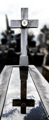 cross and Its reflection in a puddle in the cementery