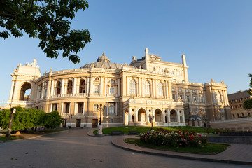 Fototapeta na wymiar Ukraine, Odessa, 13th of June 2019. Side view of the national academic opera building and the park with beautiful flower beds during a sunny day
