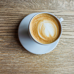White cup of coffee on wood table background