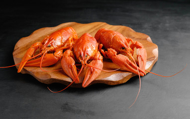 lobsters on wooden board on black background