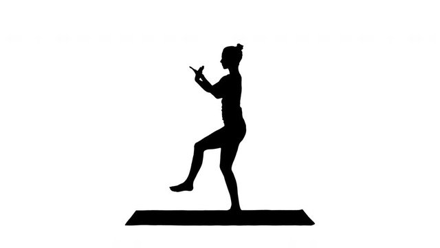 Silhouette Beautiful young woman doing yoga exercise for ankles, calves, thighs, hips and shoulders, Eagle Pose, Garudasana.