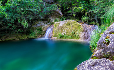 Urederra waterfall in deep forest
