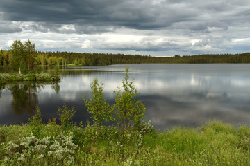 Northern forest lake before thunderstorm. Finnish Lapland