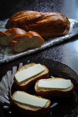 Vertical photo, in the background a fresh loaf, in the foreground - fresh sandwiches with melted cheese in a plate