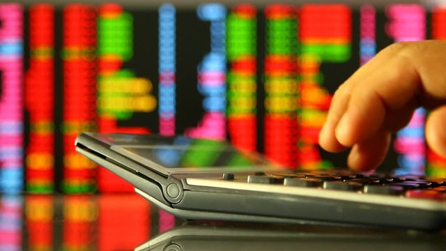 Calculator  with stock exchange board background , in studio Chiangmai Thailand