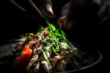 Chef is cooking salad on kitchen 