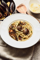 selective focus of delicious pasta with seafood and grated cheese on napkin