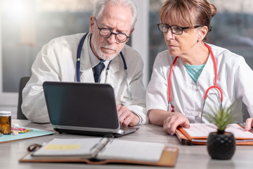 Fototapeta premium Two doctors discussing about medical report on laptop